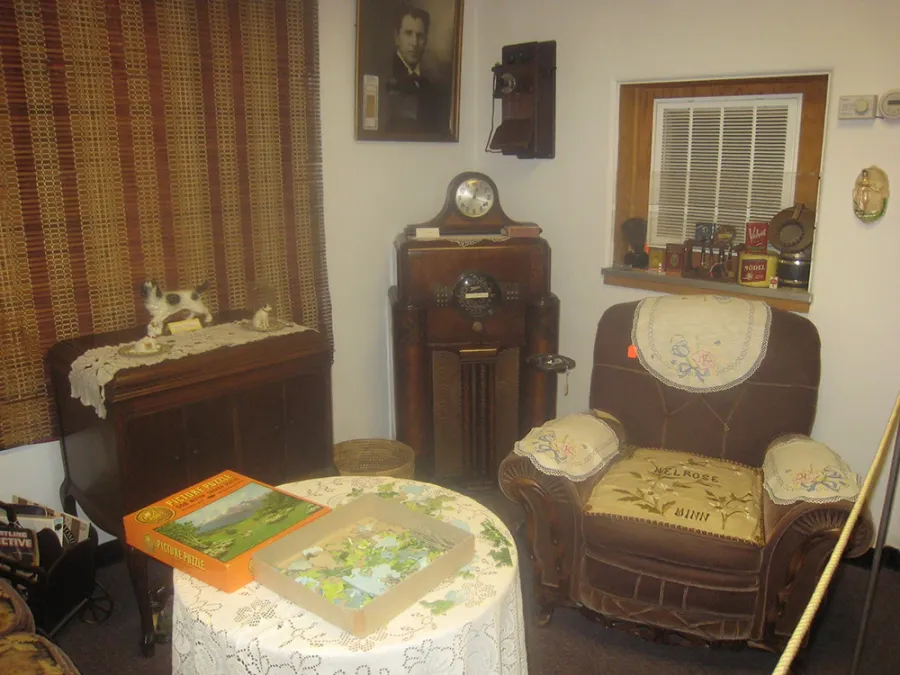 Parlor exhibit with an old radio, armchair and table